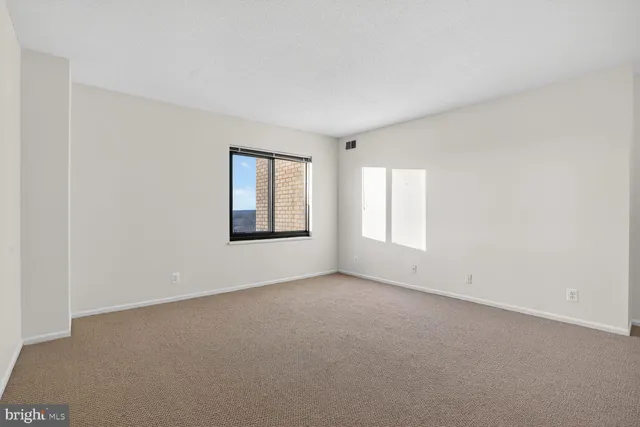 an empty room with windows and closet