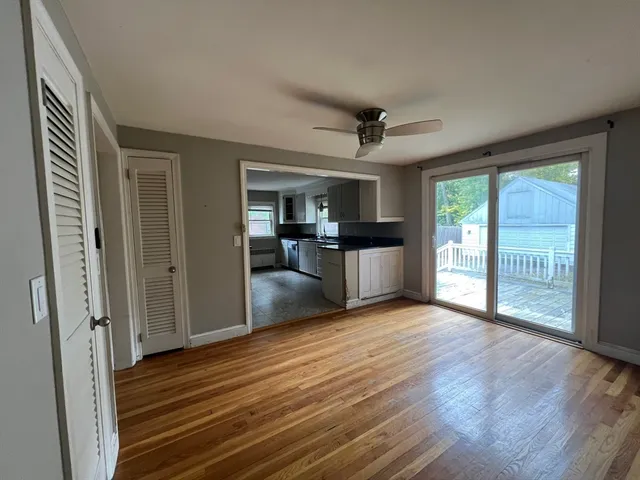 a view of a livingroom with wooden floor and a ceiling fan