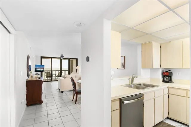 a view of a dining room with furniture a kitchen and chandelier