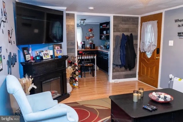 a living room with furniture a flat screen tv and kitchen view