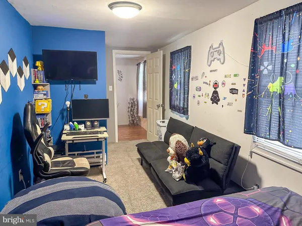a living room with furniture a flat screen tv and a floor to ceiling window