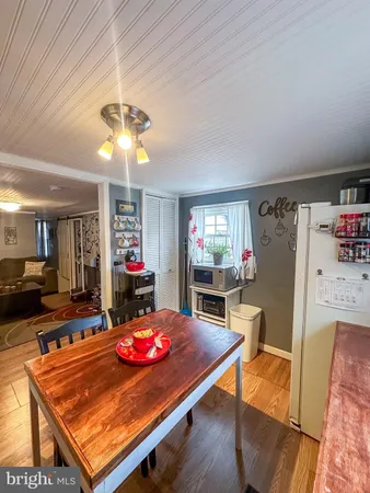 a room with table chairs and kitchen view