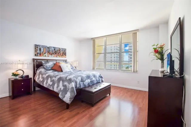 a bedroom with a large bed and a flat tv screen on dresser