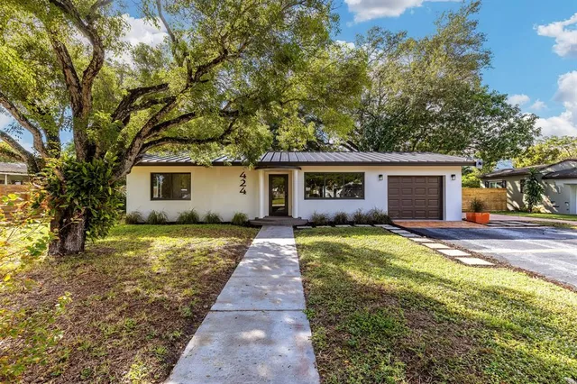 a front view of house with yard and trees around