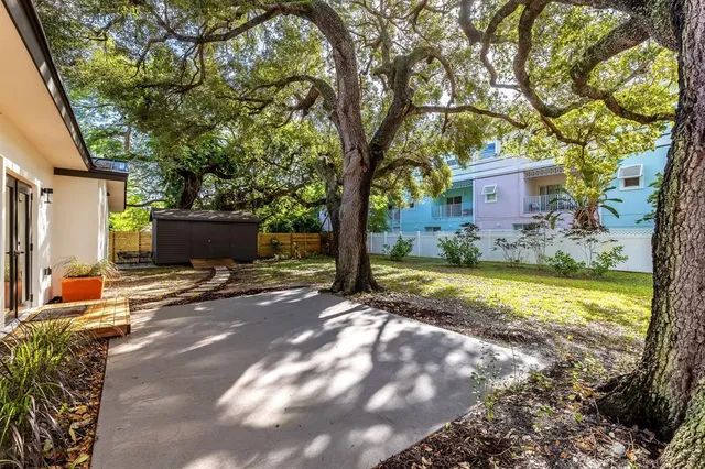 a view of a house with backyard and a tree