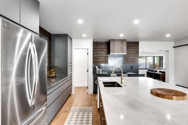 a kitchen with stainless steel appliances granite countertop a refrigerator a sink and a stove