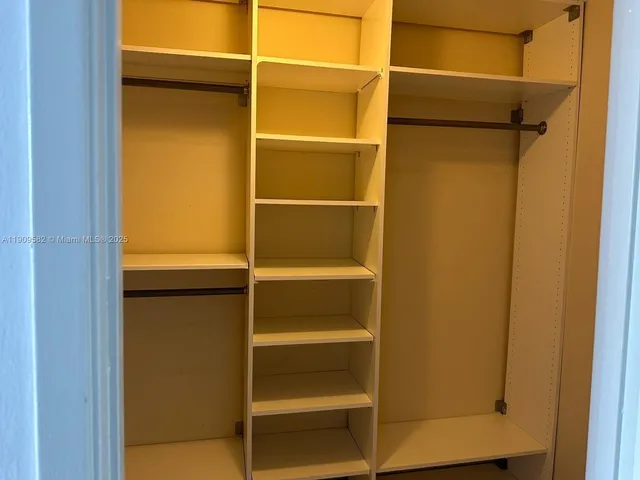 a view of walk in closet with empty racks
