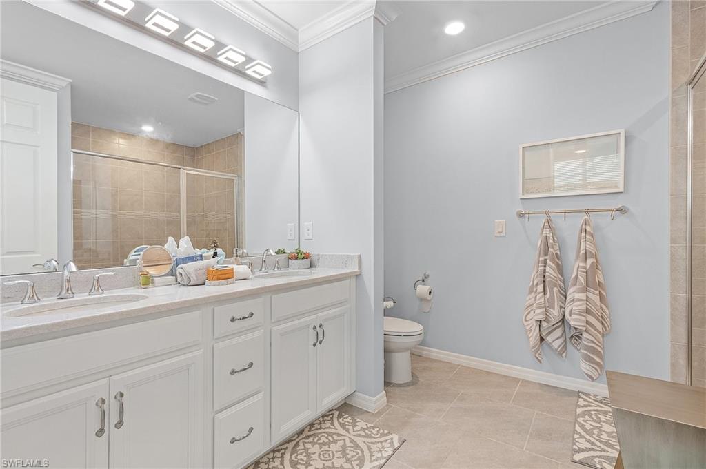 14618 Edgewater Circle Naples, FL 34114 - Photo 20 of 30 Bathroom with a shower with door, toilet, tile patterned flooring, vanity, and ornamental molding