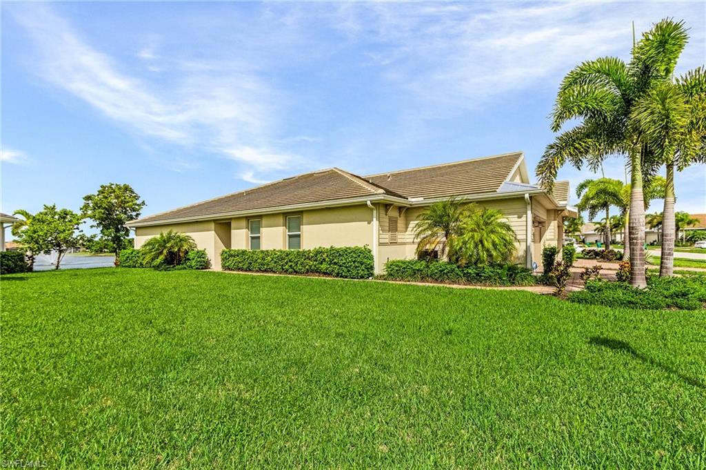 14618 Edgewater Circle Naples, FL 34114 - Photo 2 of 30 View of property exterior featuring a yard