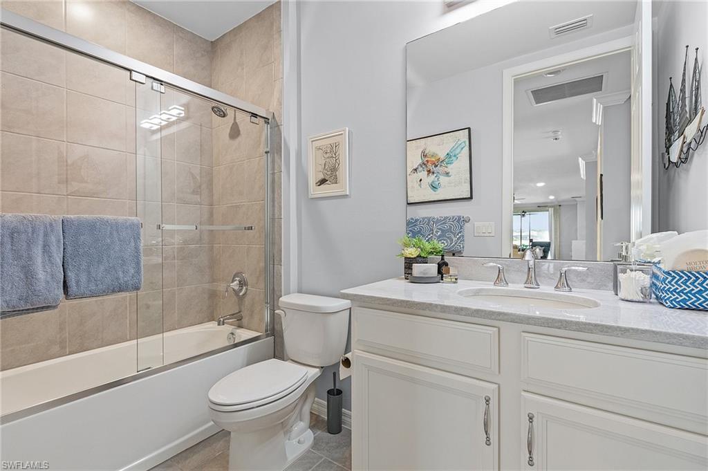 14618 Edgewater Circle Naples, FL 34114 - Photo 24 of 30 Full bathroom with tile patterned floors, toilet, vanity, and combined bath / shower with glass door