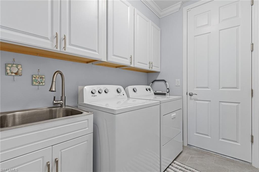 14618 Edgewater Circle Naples, FL 34114 - Photo 25 of 30 Laundry area featuring washer and clothes dryer, ornamental molding, sink, cabinets, and light tile patterned floors