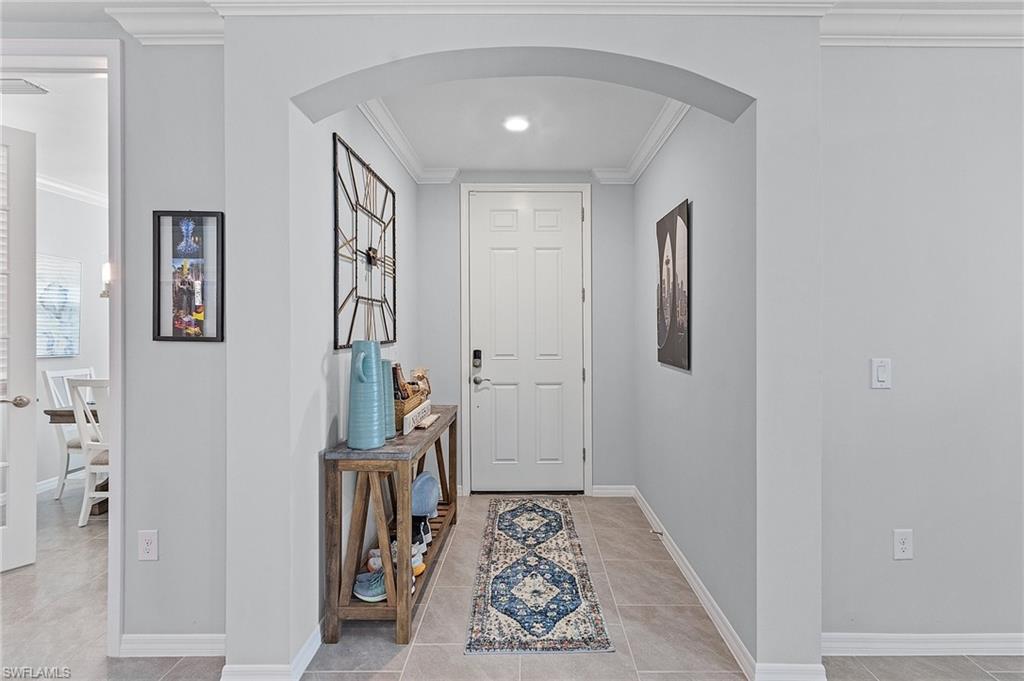 14618 Edgewater Circle Naples, FL 34114 - Photo 5 of 30 Foyer with crown molding and light tile patterned flooring