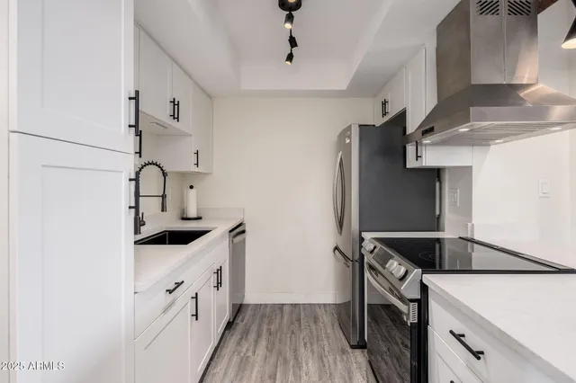 a kitchen with stainless steel appliances granite countertop a sink stove and refrigerator