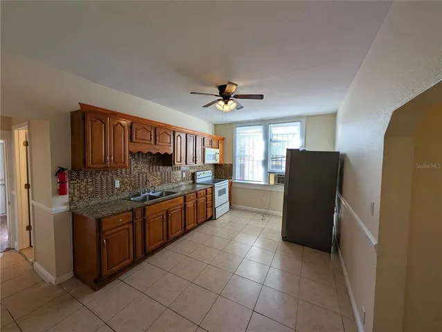 a kitchen with stainless steel appliances granite countertop a refrigerator and a stove top oven