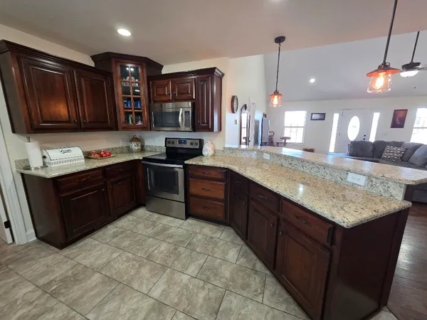 a living room with furniture a fireplace and a chandelier