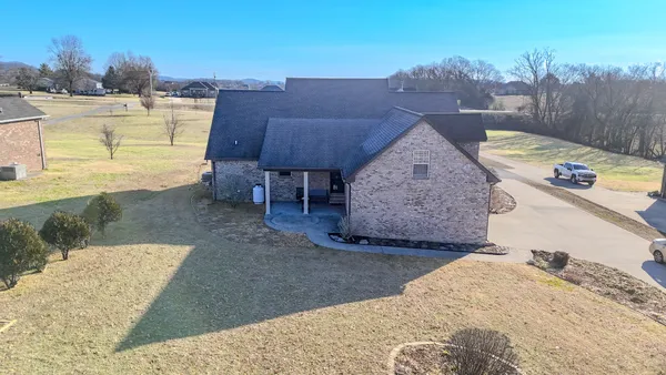 an aerial view of a house with a yard and lake view