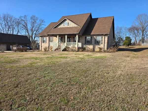 a front view of a house with a yard and seating space