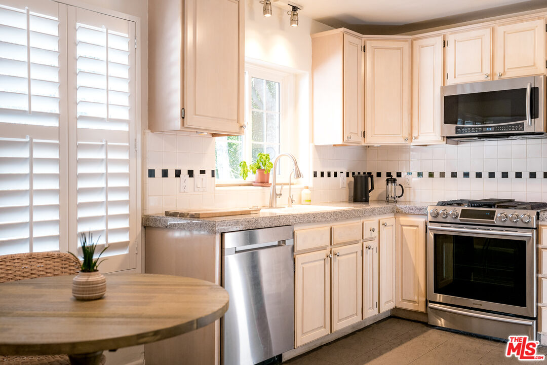 5849 Goodland Avenue Valley Village, CA 91607 - Photo 8 of 25 a kitchen with stainless steel appliances a stove a sink and white cabinets