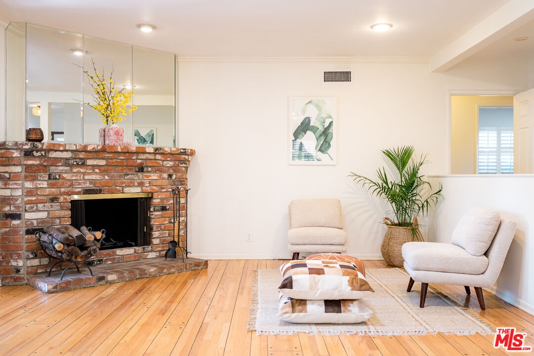 5849 Goodland Avenue Valley Village, CA 91607 - Photo 9 of 25 a living room with furniture a fireplace and a potted plant