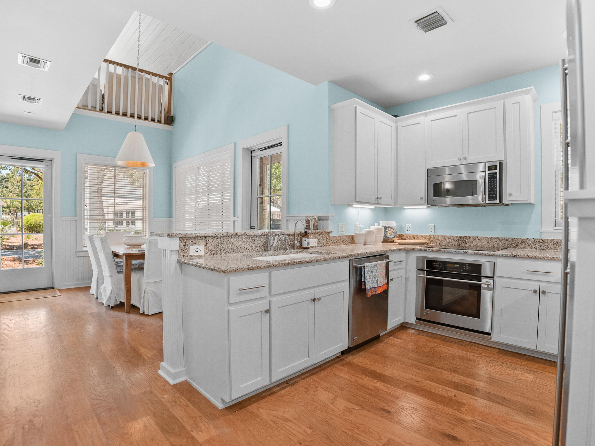 253 Salt Lane Watersound, FL 32461 - Photo 16 of 56 a kitchen with kitchen island granite countertop a stove top oven a sink a counter space and cabinets