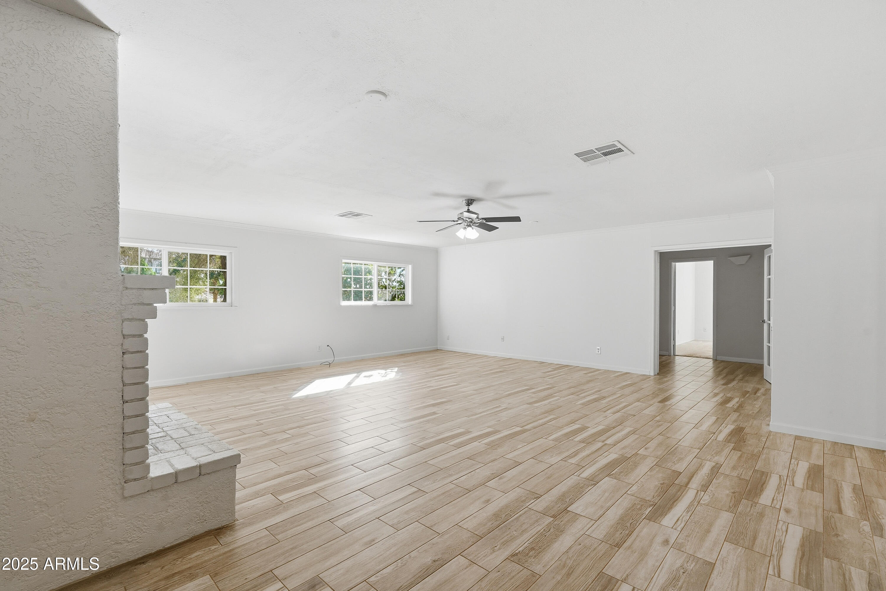 21047 South 156th Street Gilbert, AZ 85298 - Photo 12 of 40 an empty room with wooden floor ceiling fan and windows