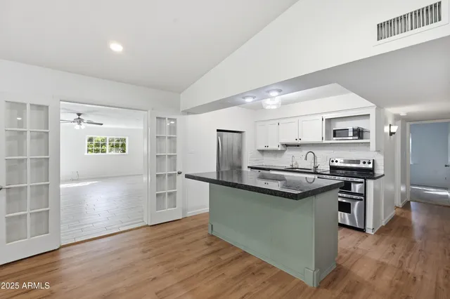 a kitchen with stainless steel appliances granite countertop a sink stove and refrigerator