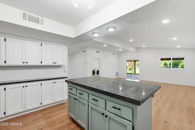 a kitchen with a sink window and cabinets