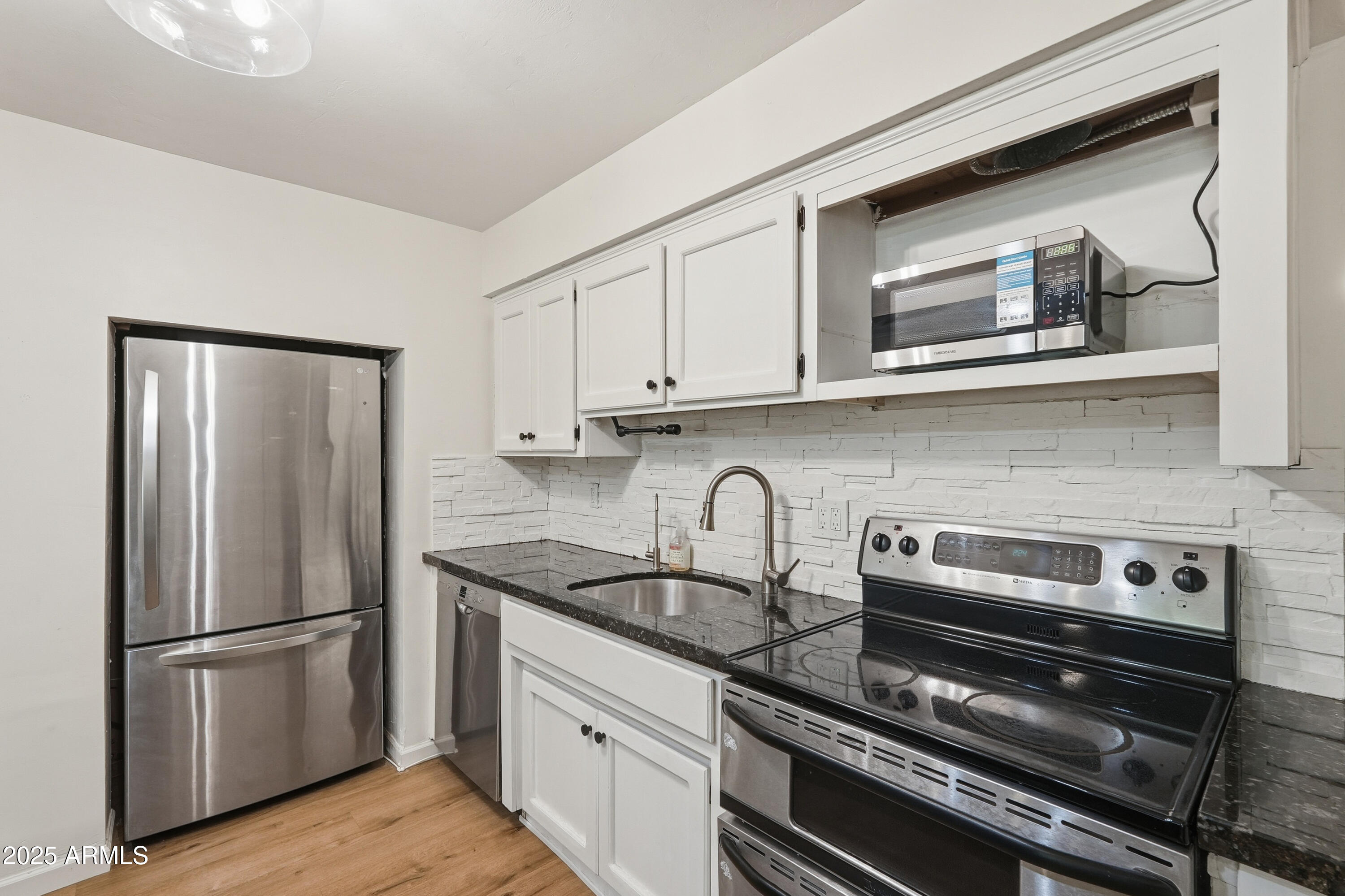 21047 South 156th Street Gilbert, AZ 85298 - Photo 18 of 40 a kitchen with stainless steel appliances granite countertop a refrigerator and a stove top oven