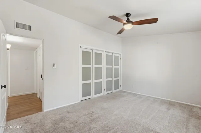 a view of a livingroom with a ceiling fan and wooden floor