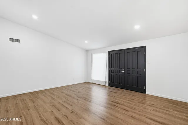 a view of an empty room with wooden floor