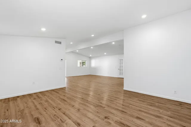 a view of empty room with wooden floor