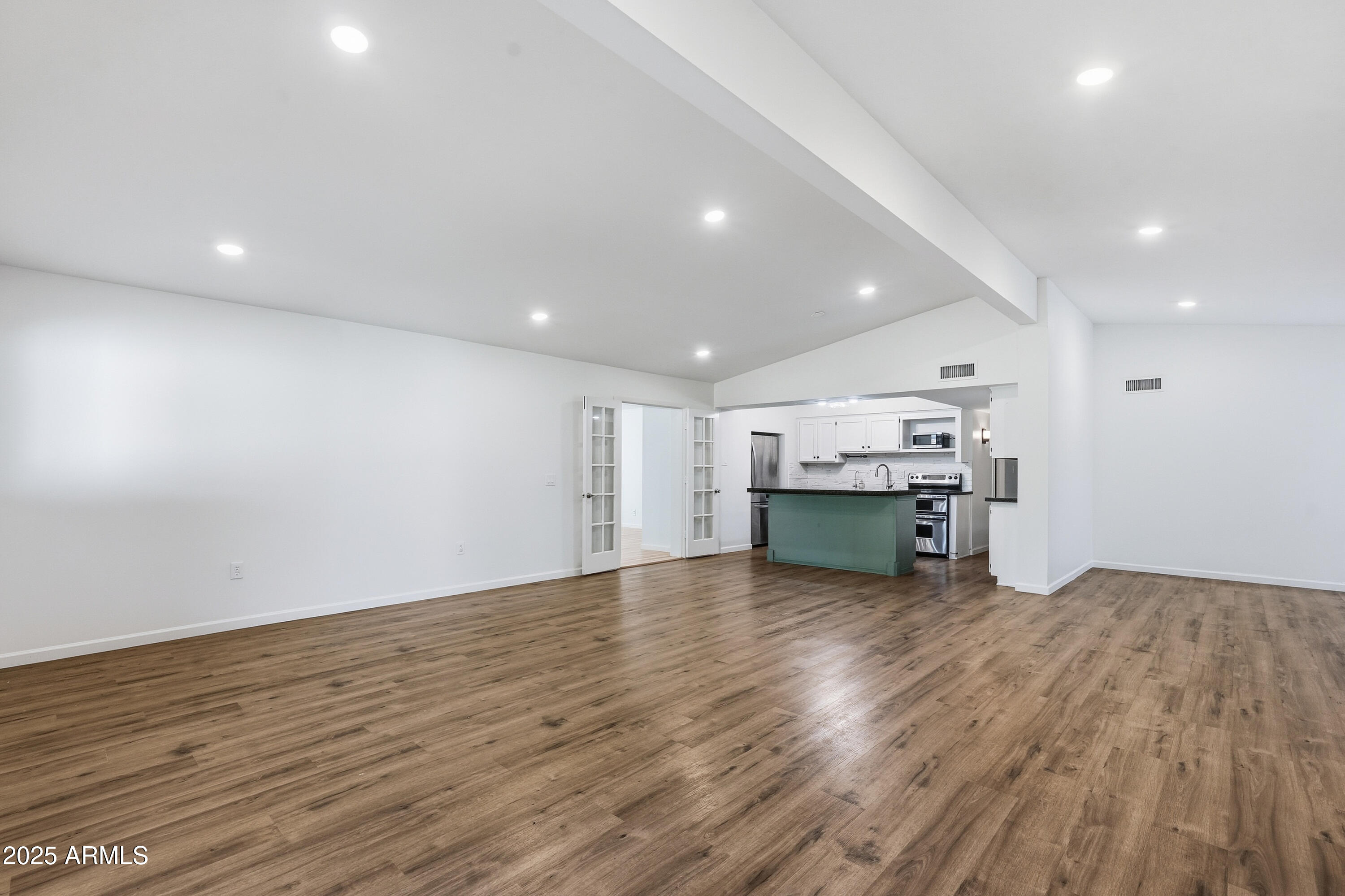 21047 South 156th Street Gilbert, AZ 85298 - Photo 7 of 40 an empty room with wooden floor kitchen view and a window