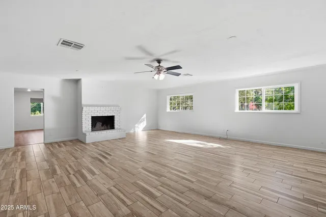a view of a livingroom with wooden floor and a ceiling fan