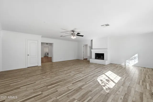 a view of empty room with wooden floor and fireplace