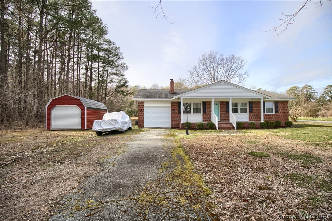 1373 Fitchetts Wharf Road Moon, VA 23119 - Photo 1 of 22 Single story home featuring a porch, a front yard, and an outdoor structure