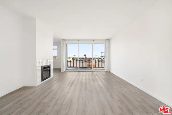 a view of an empty room with a fireplace and a window