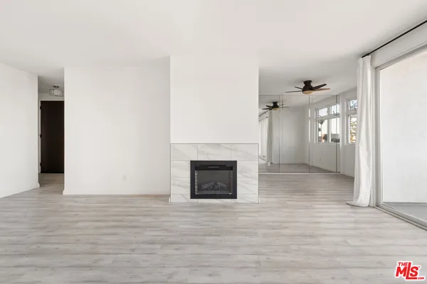 a view of a livingroom with wooden floor and a fireplace