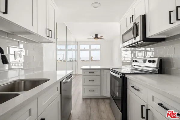 a kitchen with white cabinets and white appliances