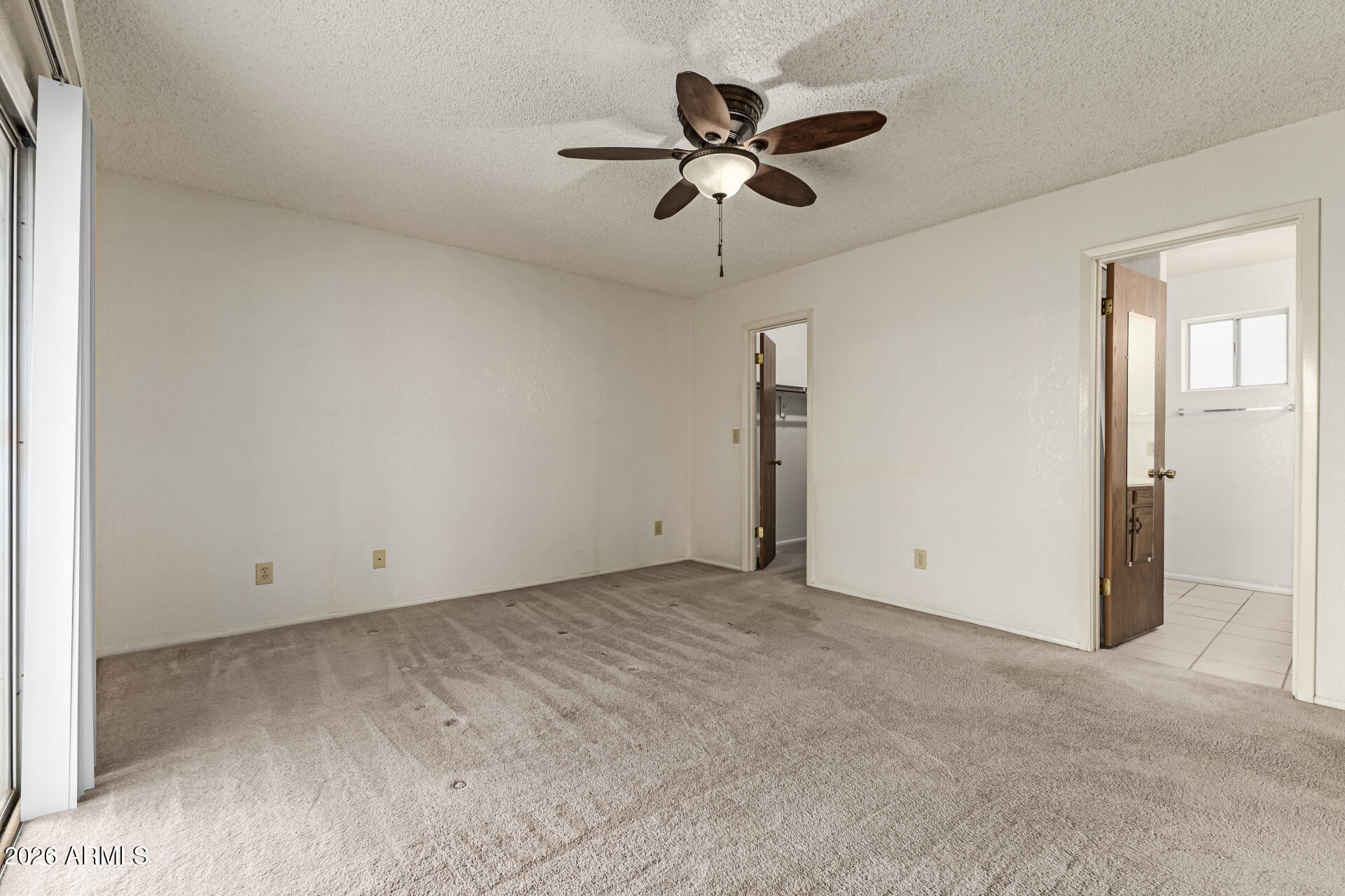 7926 West Shangri-la Road Peoria, AZ 85345 - Photo 15 of 32 an empty room with a ceiling fan and a window