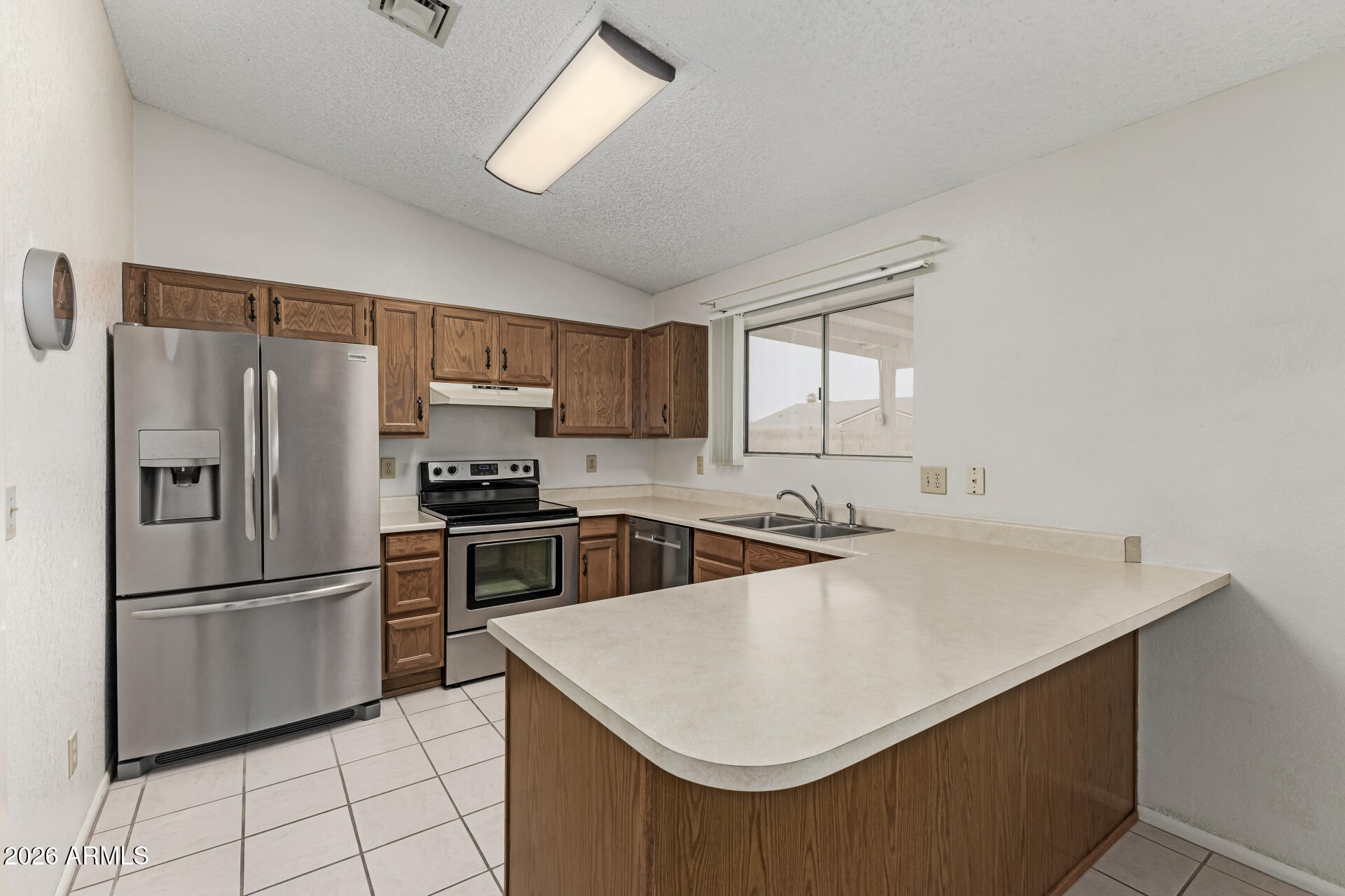 7926 West Shangri-la Road Peoria, AZ 85345 - Photo 9 of 32 a kitchen with stainless steel appliances a refrigerator sink and cabinets