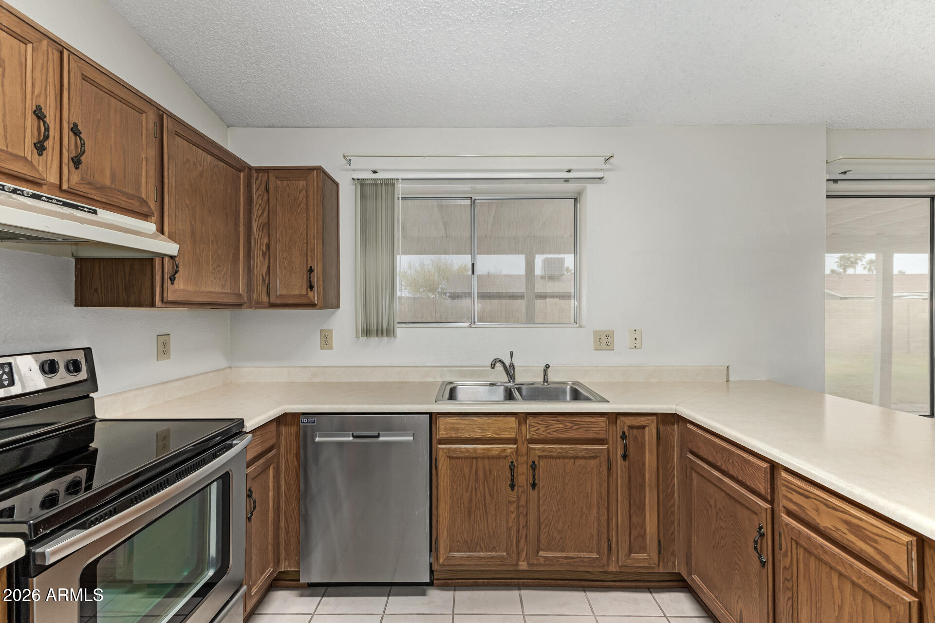 7926 West Shangri-la Road Peoria, AZ 85345 - Photo 10 of 32 a kitchen with stainless steel appliances granite countertop a sink stove and cabinets