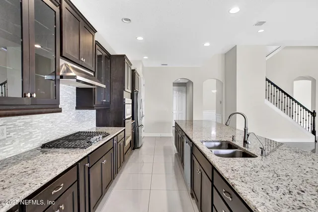 a kitchen with sink stove and refrigerator