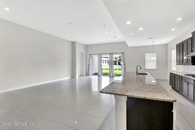 a kitchen with granite countertop kitchen island a sink appliances and a counter space