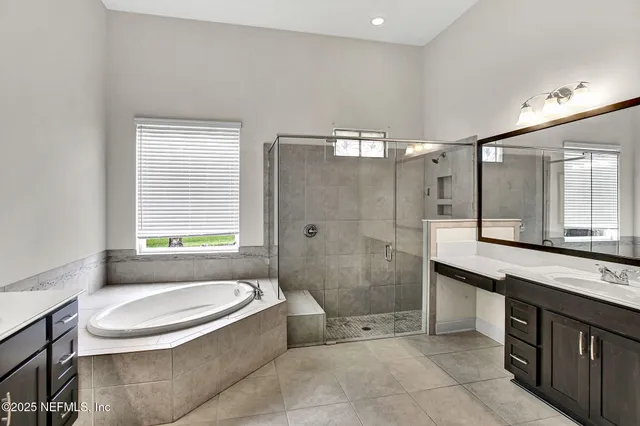 a bathroom with a granite countertop sink toilet mirror and bathtub