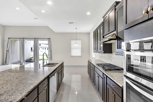 a kitchen with stainless steel appliances granite countertop a stove and a sink