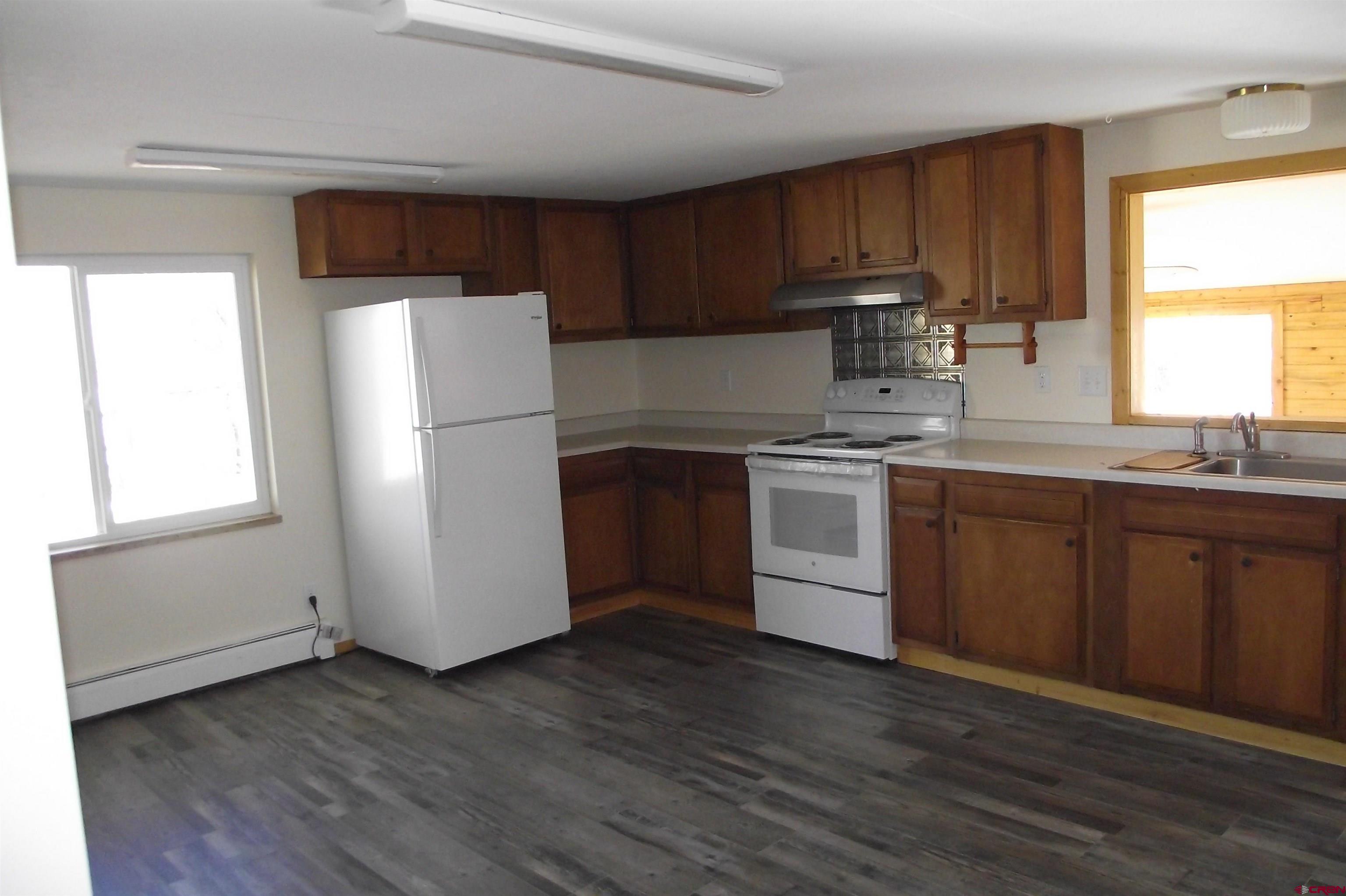 27434 Cedar Mesa Road Cedaredge, CO 81413 - Photo 15 of 36 a kitchen with a refrigerator sink and cabinets