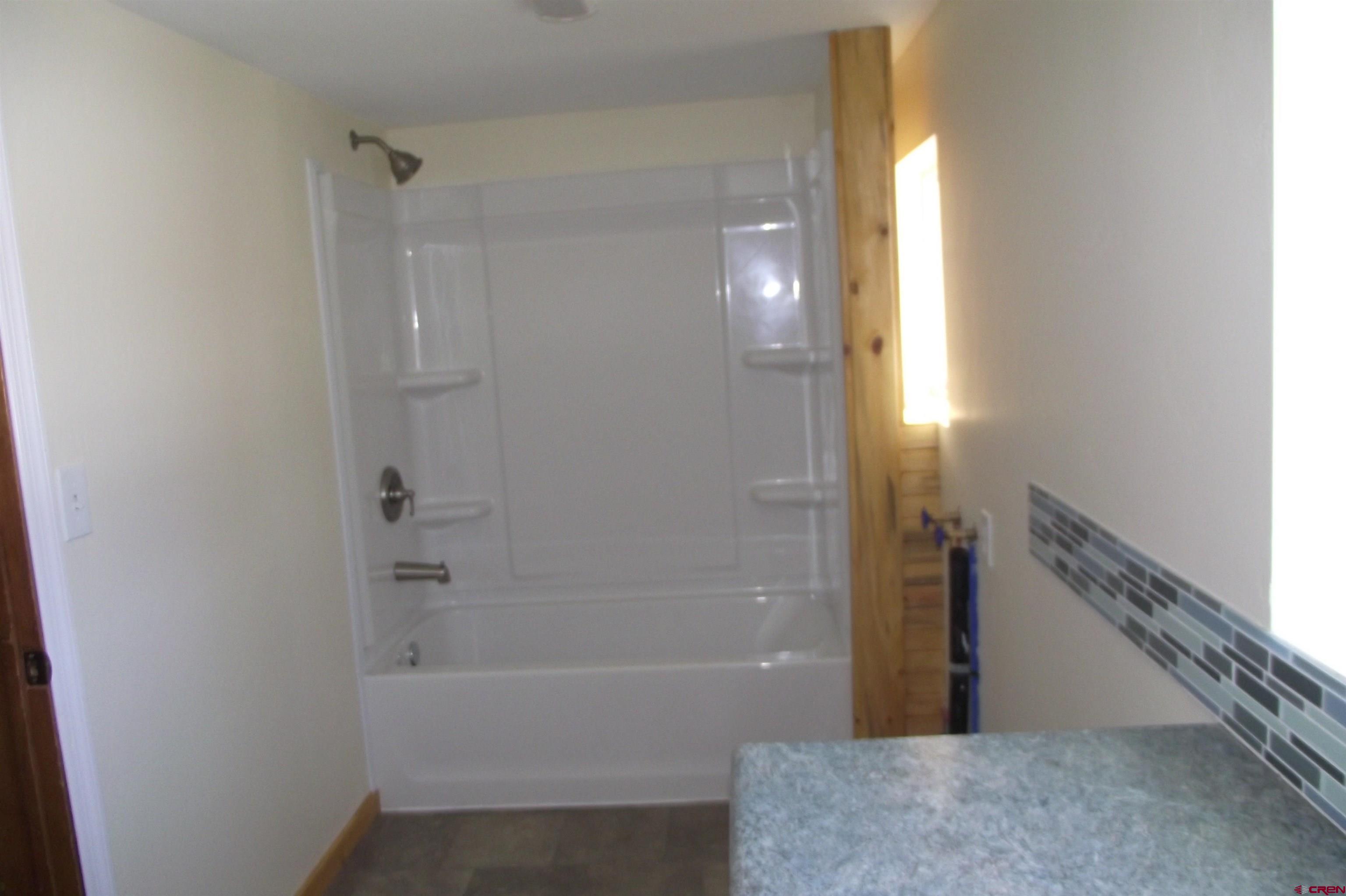 27434 Cedar Mesa Road Cedaredge, CO 81413 - Photo 21 of 36 a bathroom with a bathtub