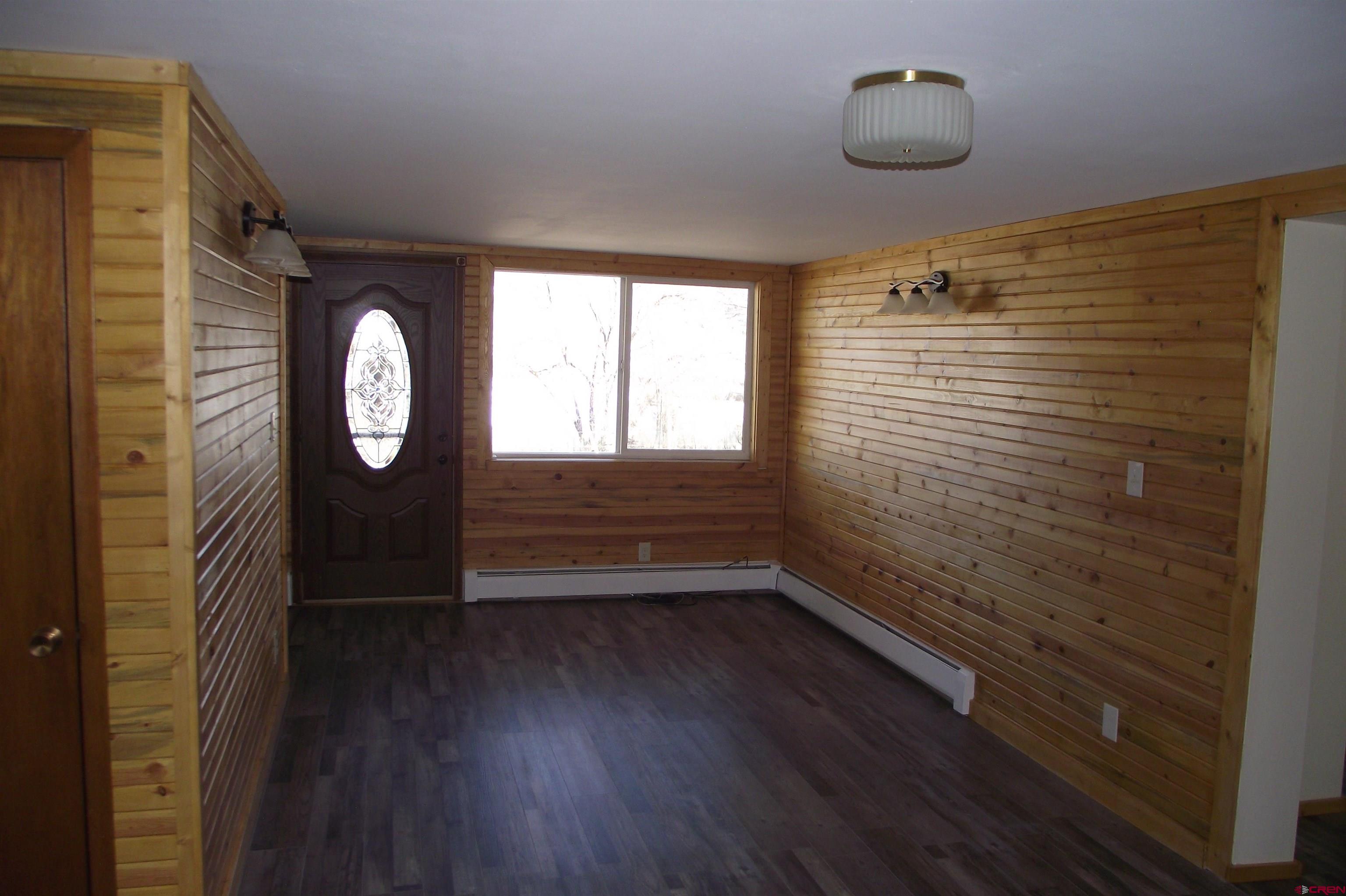 27434 Cedar Mesa Road Cedaredge, CO 81413 - Photo 22 of 36 a view of a hallway with wooden floor and a large window