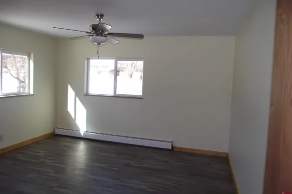 a view of an empty room with wooden floor and closet