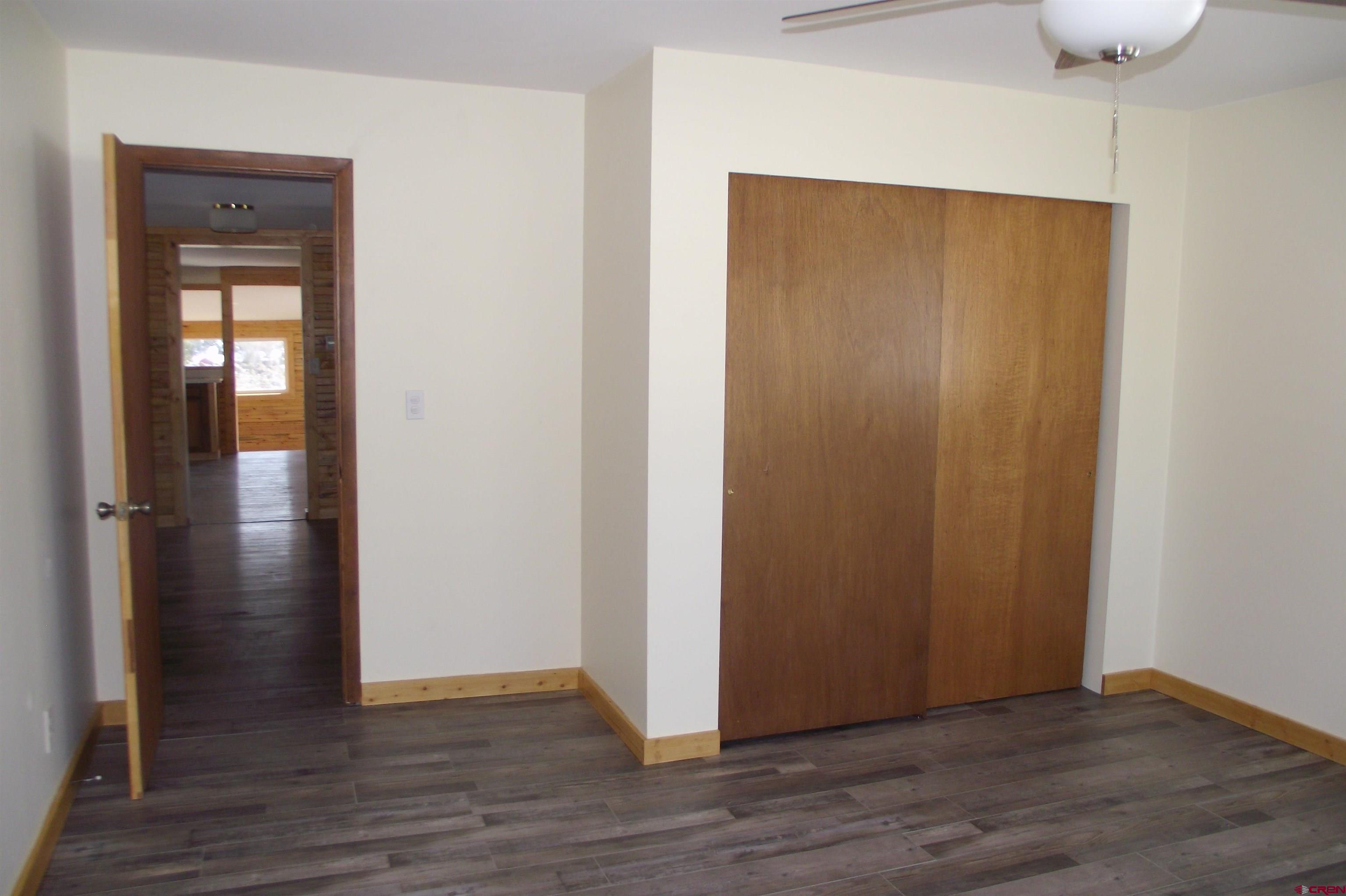 27434 Cedar Mesa Road Cedaredge, CO 81413 - Photo 24 of 36 a view of an empty room with wooden floor and closet
